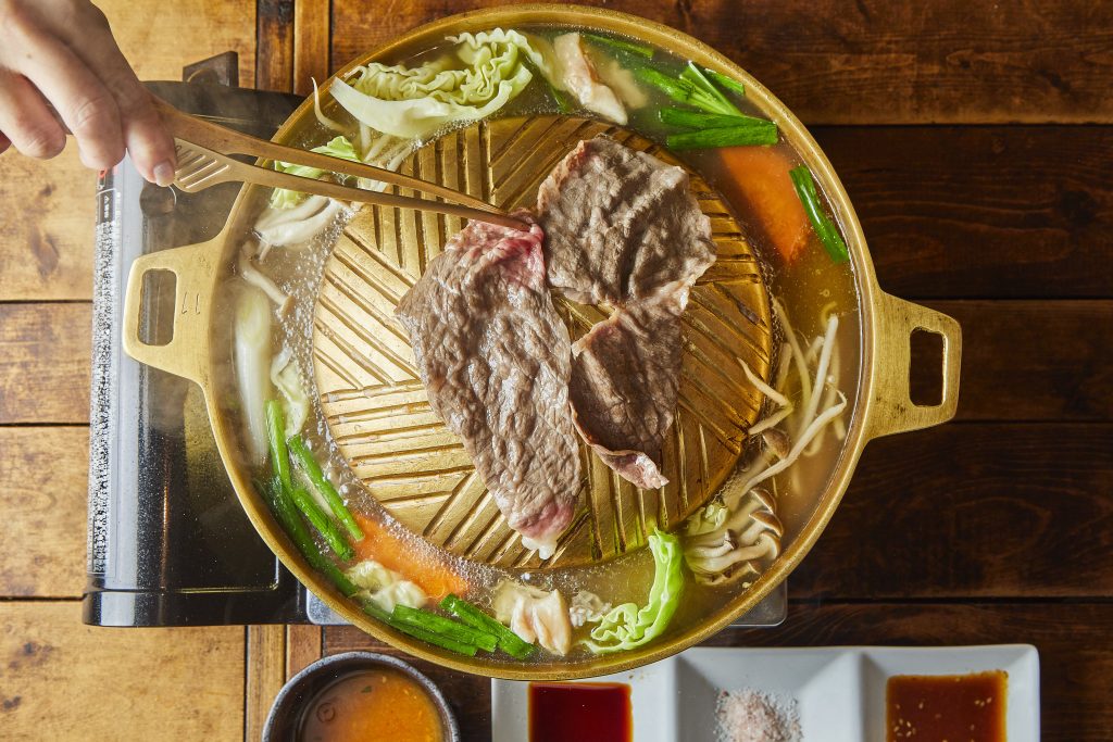 ムーガタの鍋。中央のプレートで肉を焼き、まわりのスープで野菜を煮る