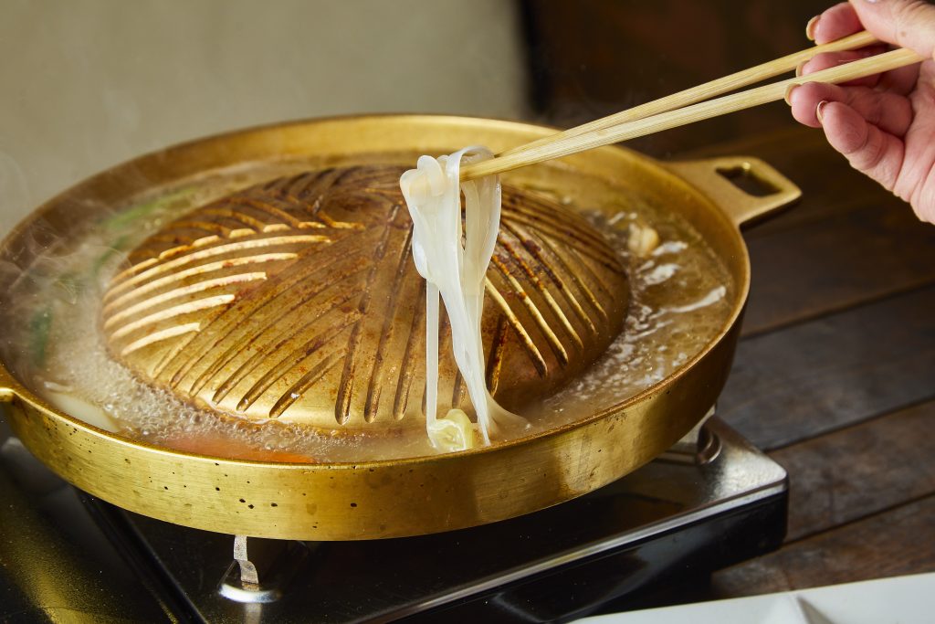 ムーガタの〆に米麺をスープに入れているところ
